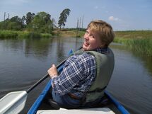 Woman sitting in a canoe paddling. Photo.