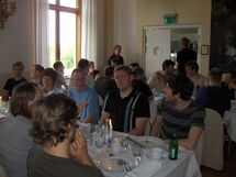 People sitting at a table, eating. Photo. 