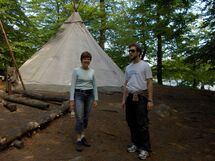 Two persons in front of a tent. Photo.