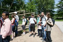 People standing outside a fence. Photo.