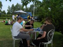 People drinking coffee around a table. Photo. 
